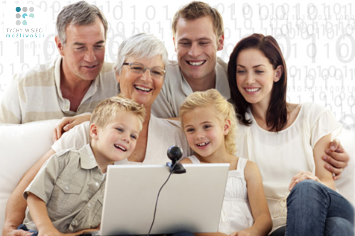 Zdjęcie członków rodziny, zarówno osób starszych, jak i rodziców i dzieci, siedzących i z uśmiechem spoglądających w ekran laptopa