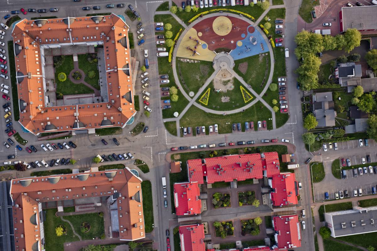Zdjecie osiedla Balbina z drona - widok na kolorowy plac zabaw i przylegające budynki.