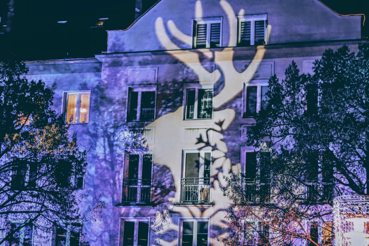 Podświetlony budynek przy placu Baczyńskiego - świetlna wizualizacja renifera podczas Jarmarku Bożonarodzeniowego