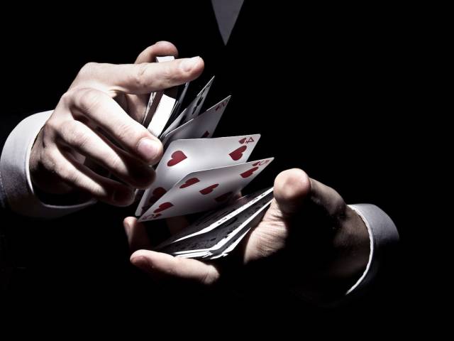 dłonie tasujące karty