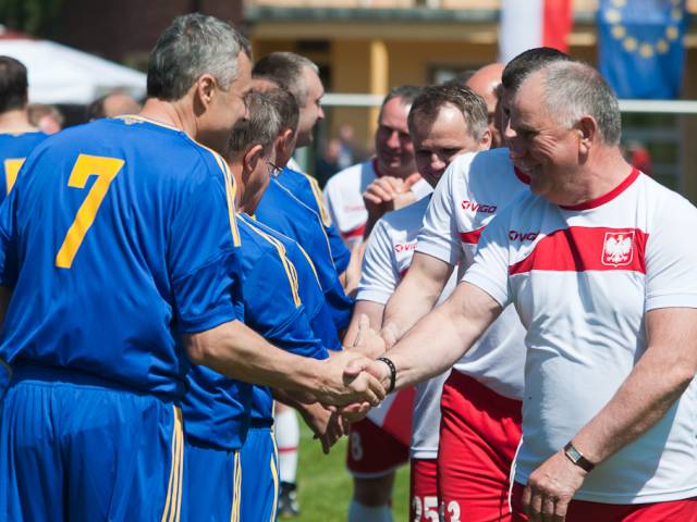 Polscy burmistrzowie i prezydenci w strojach piłkarskich witają się przed rozpoczęciem meczu z merami z Ukrainy.