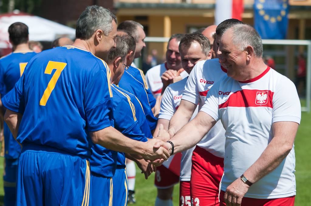 Polscy burmistrzowie i prezydenci w strojach piłkarskich witają się przed rozpoczęciem meczu z merami z Ukrainy.