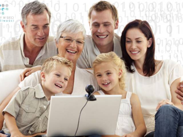 Zdjęcie członków rodziny, zarówno osób starszych, jak i rodziców i dzieci, siedzących i z uśmiechem spoglądających w ekran laptopa