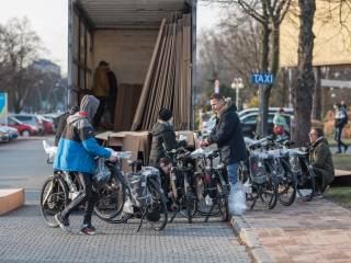 Zdjęcie cieżarówki i osób wyciągających z niej rowery elektryczne. Autor: Kamil Peszat