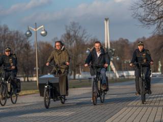 Zdjęcie czterech osób jadących na rowerach elektrycznych, w tym dwóch pracowników Straży Miejskiej.