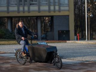 Zdjęcie osoby na rowerze elektrycznym ze skrzynią.