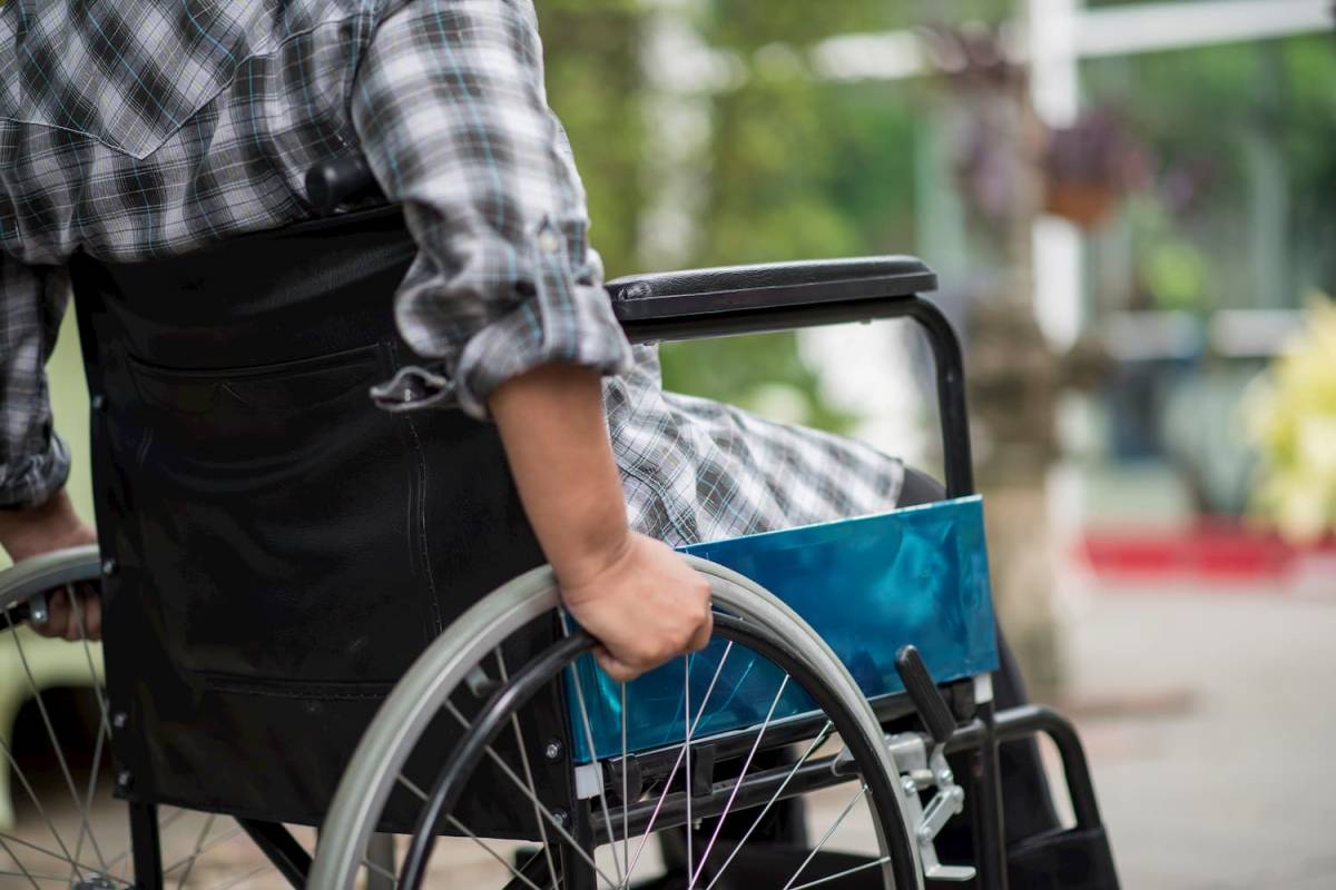 osoba na wózku inwalidzkim, kadr na rękę trzymającą koło