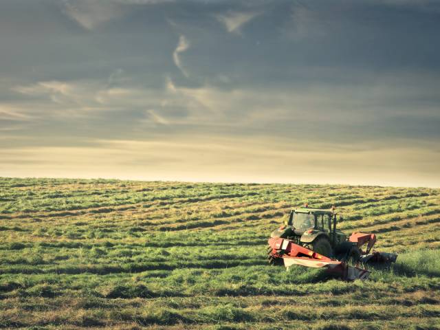Zdjęcie przedstawiające traktor na zielonym polu.