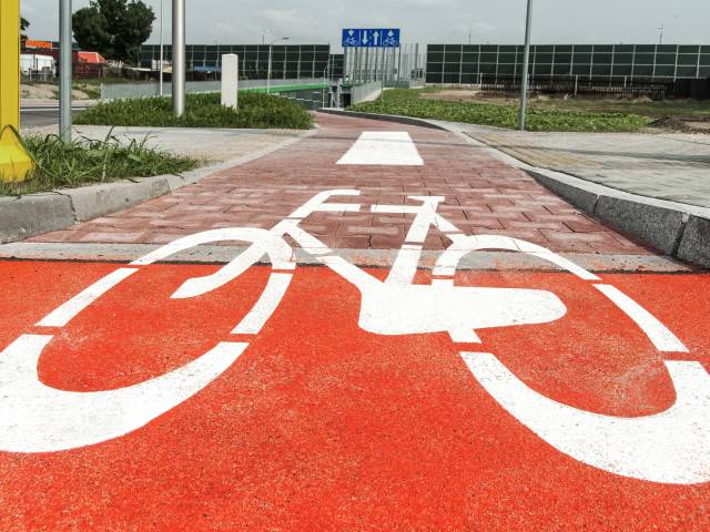 Zdjęcie przedstawiające drogę rowerową - wymalowany znak na czerwonej nawierzchni.