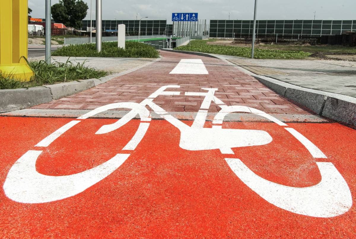 Zdjęcie przedstawiające drogę rowerową - wymalowany znak na czerwonej nawierzchni.