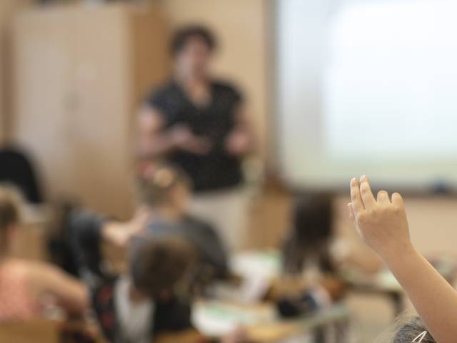 Podniesiona ręka dziecka w klasie szkolnej