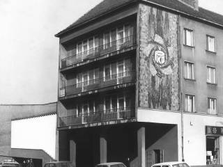Narożny budynek z podcieniem i mozaiką w pierzei północnej placu, ok. 1980 r. Fotografia ze zbiorów Muzeum Miejskiego w Tychach