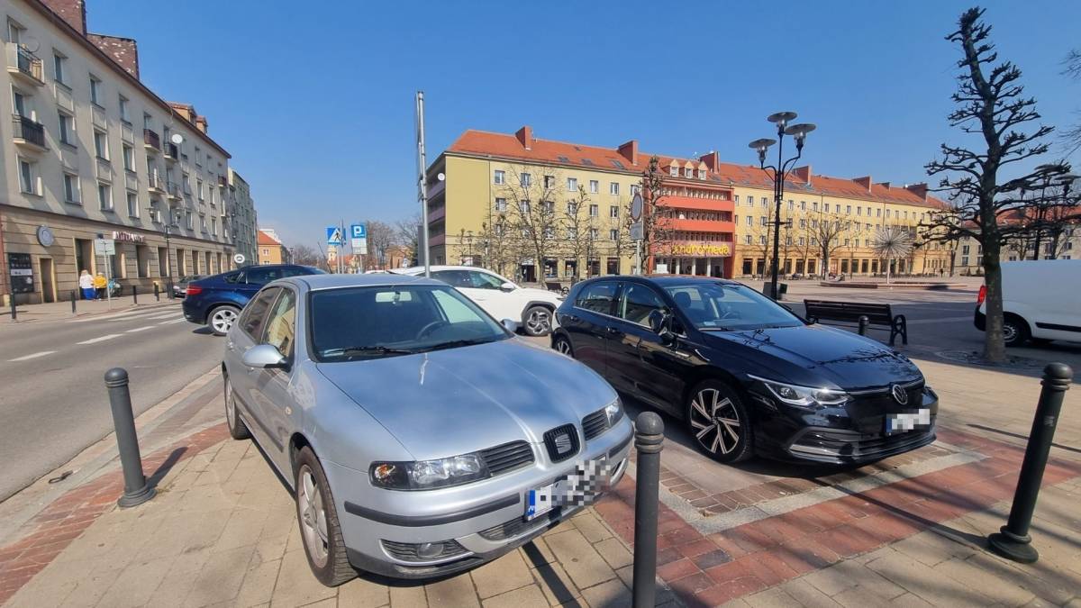 Parking na Placu Baczyńskiego - na pierwszym planie zdjęcia dwa samochody.