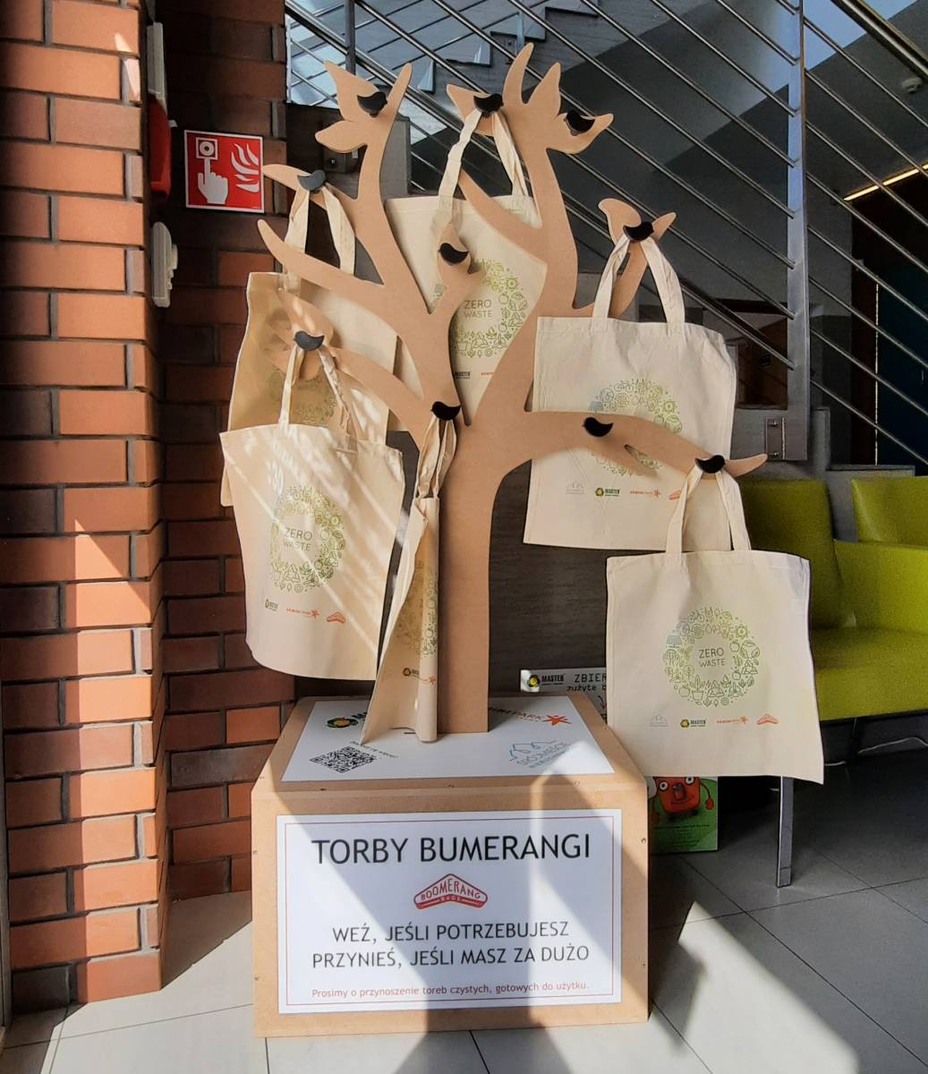 Torby bumerangi (materiałowe jasne torby) na wieszaku imitującym drzewo