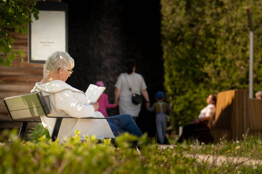 Kobieta siedząca na ławce i czytająca książkę a Parku bł. Karoliny przy tężni Autor: Kamil Peszat