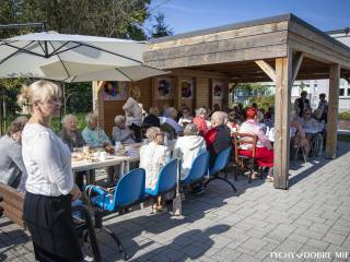 Pensjonariusze i pracownicy siedzący przy stołach podczas obchodów 40-lecia Dziennego Domu Opieki Społecznej "Wrzos". Autor: Piotr Podsiadły