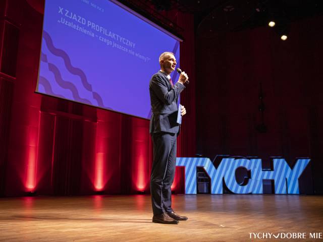 Maciej Gramatyka - zastępca prezydenta miasta Tychy ds. społecznych przemawia z mikrofonem na scenie podczas otwarcia X Zjazdu Profilaktycznego.