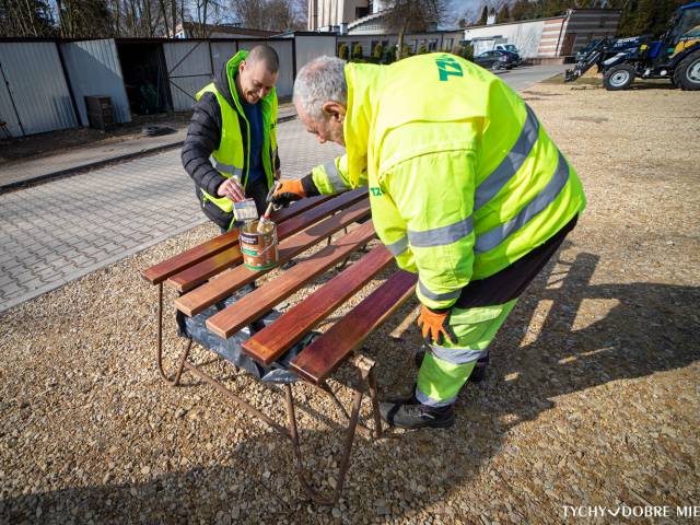 Dwóch pracowników TZUK odmalowuje ławki z tyskich parków