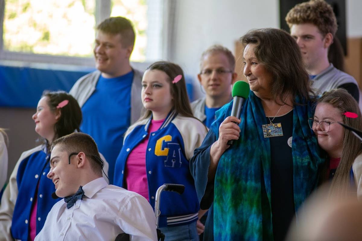 Polska aktorka stoi z mikrofonem, wokół niej dzieci z Zespołu Szkół Specjalnych nr 8.