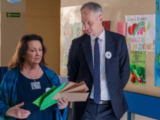 Kobieta i mężczyzna rozmawiają na korytarzu szkolnym.