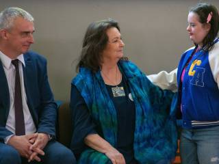 Kobieta i mężczyzna uśmiechają sie do dziewczynki.