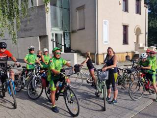 Grupa rowerzystów pozuje do zdjęcia na tle  budynku Muzeum Miejskiego w Tychach.