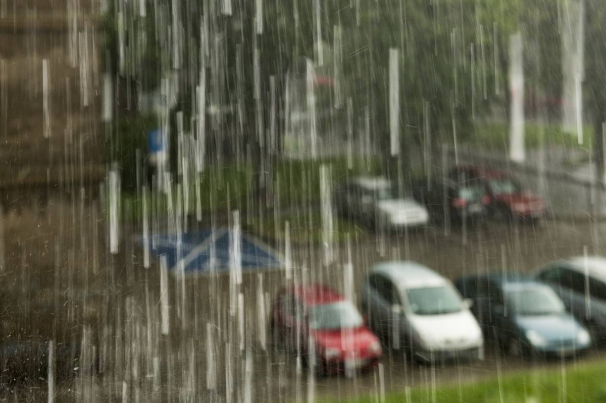 Widok z okna na parking w deszczu.