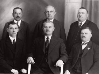 Zarząd Gminy Tychy, 1939 r. Siedzą (od lewej): ławnik Jan Skocza, naczelnik gminy Jan Wieczorek, ławnik Paweł Sojka. Stoją ławnicy (od lewej): Gustaw Pisarzowski, Mikołaj Kściuk, Marcin Pisarzowski. Fotografia stanowiąca skan z publikacji: L. Musioł, Tychy. Monografia historyczna, Tychy 1939